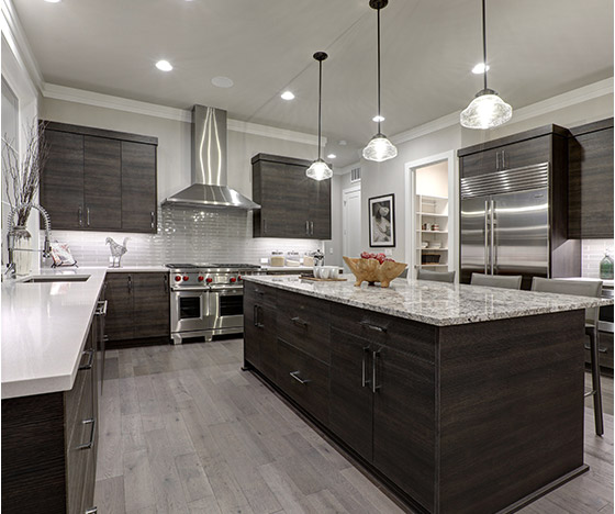 Spacious kitchen with dark brown stained cabinets and granite island countertop