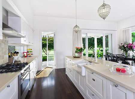 Smaller kitchen with white cabinets and island and dark hardwood floors