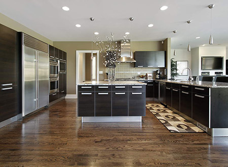 Spacious kitchen with black cabinets and island and hardwood flooring
