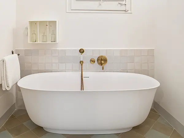 A freestanding tub with golden water fixtures