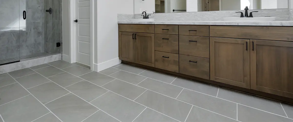 Gray tile flooring with large wooden vanity