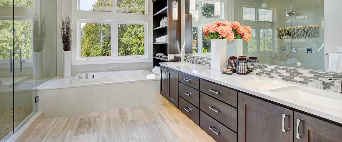 A bathroom with a large wooden vanity with a flower vase