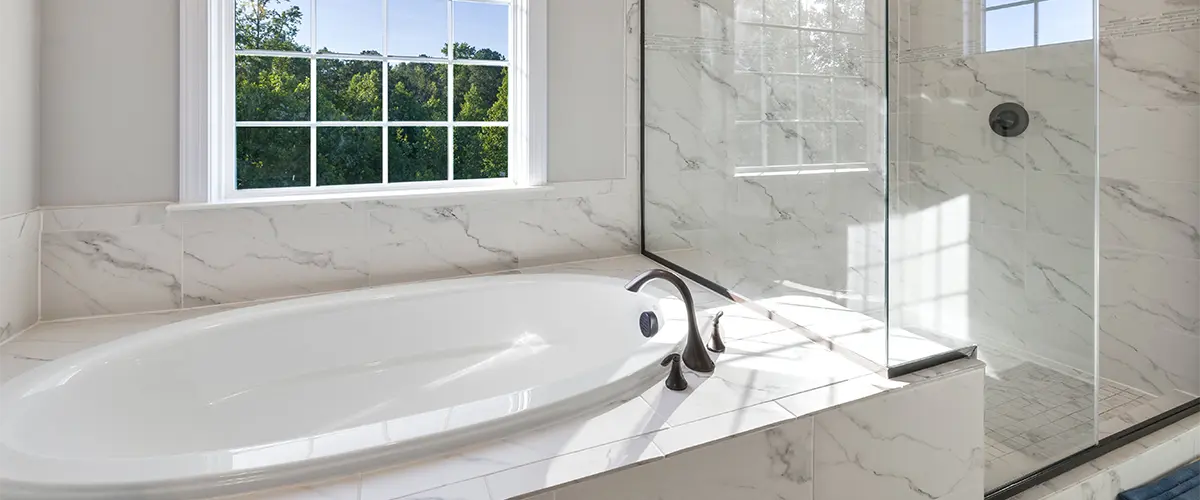 A bathroom remodel in Washington with a tub and glass walk-in shower