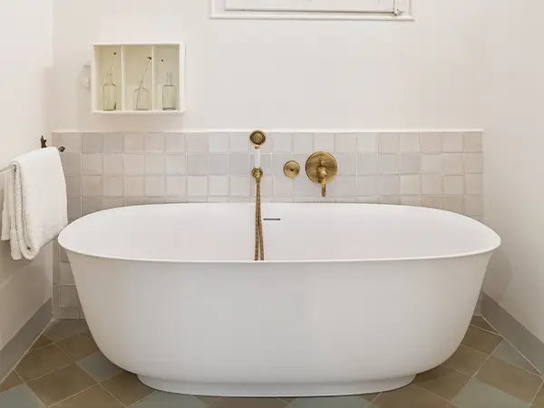 Freestanding tub with golden water fixtures