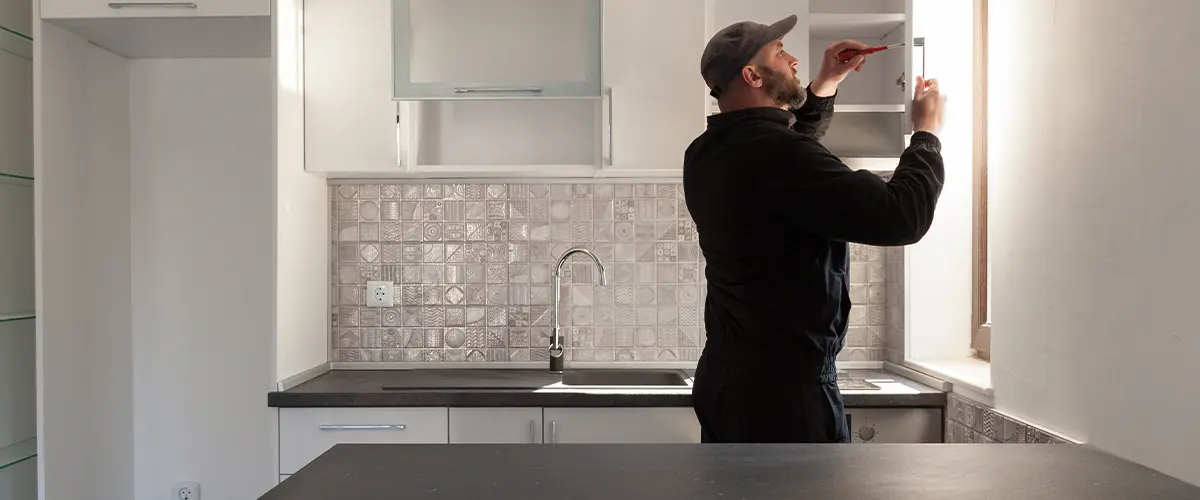 A contractor working on kitchen cabinets for a kitchen remodel