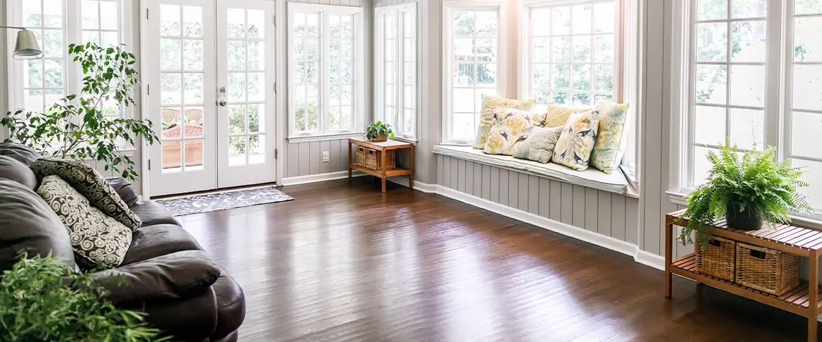 A sunroom with wood flooring and plants