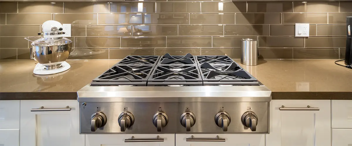A big kitchen range with a tile backsplash