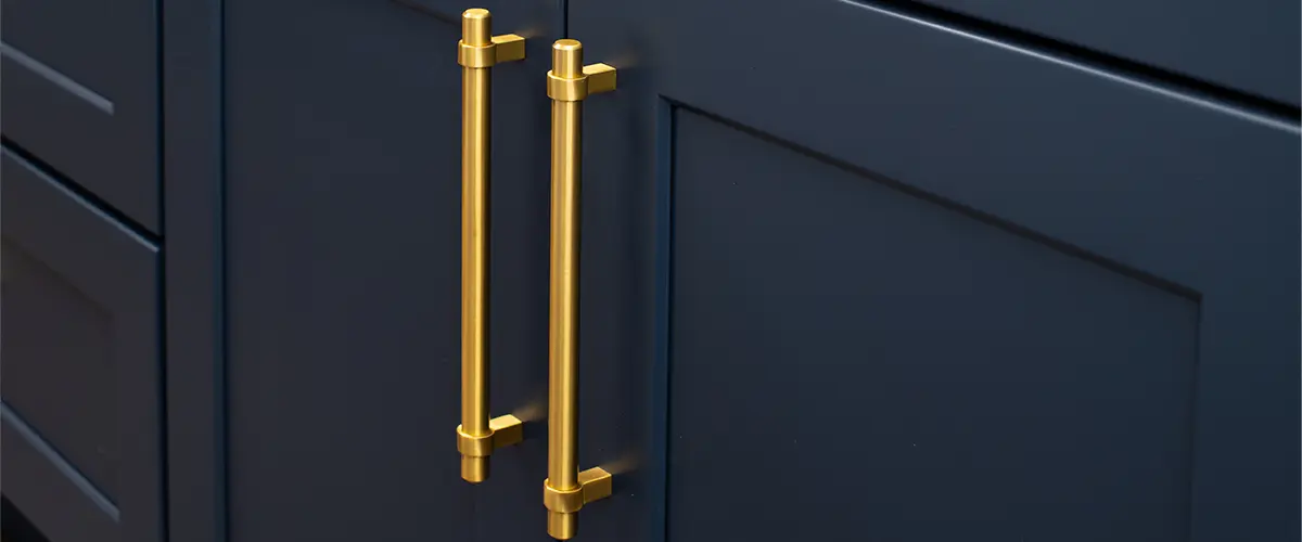 Golden cabinet hardware on navy blue kitchen cabinet