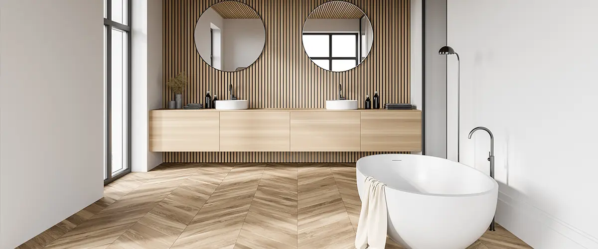 An upscale bathroom with hardwood floor and freestanding tub