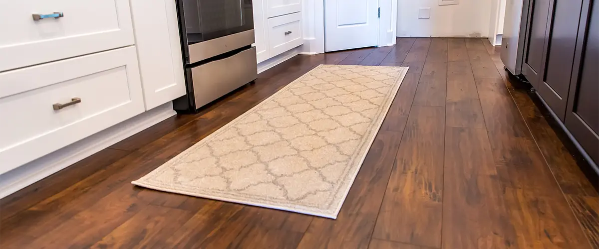 Hardwood kitchen floor with a rectangular carpet