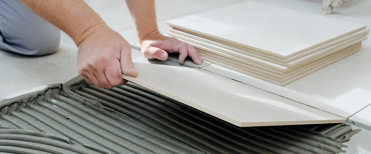 close up hands installing a popular bathroom flooring option