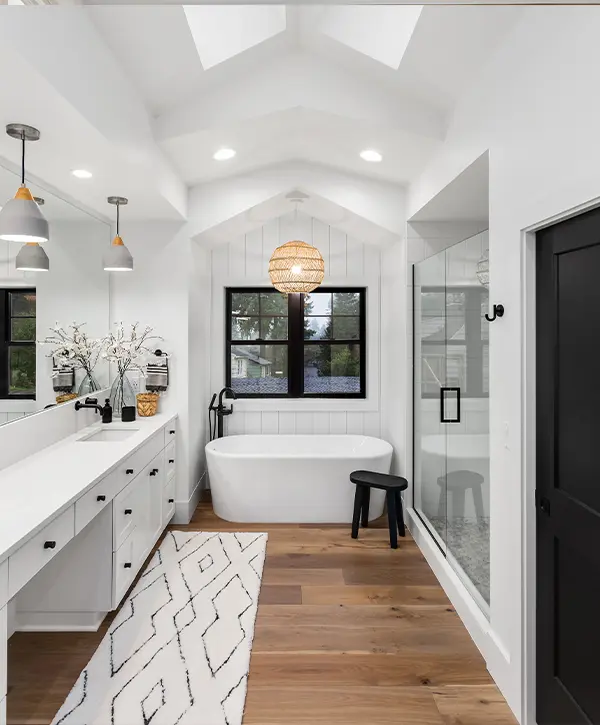Modern bathroom with wood flooring and white cabinets