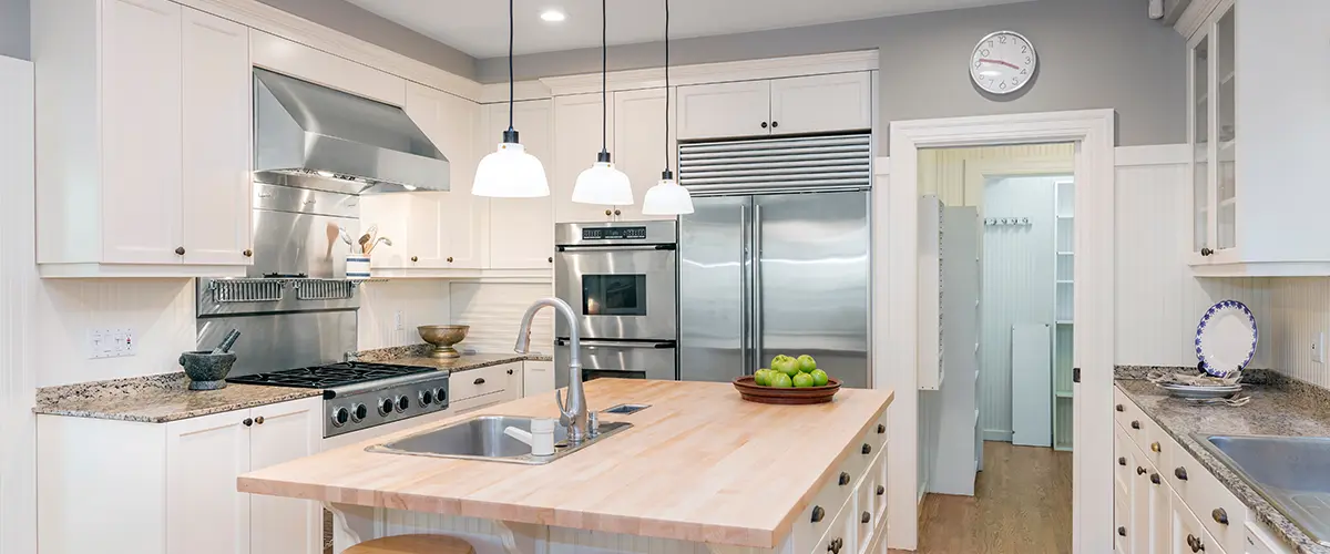 mazing Luxury Kitchen Interior in white with wooden floor and kitchen island.