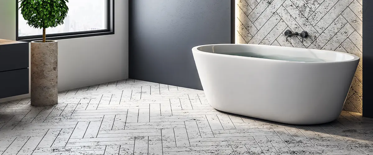 Modern bathroom with a freestanding tub, herringbone tile accent wall, and stylish pendant lights