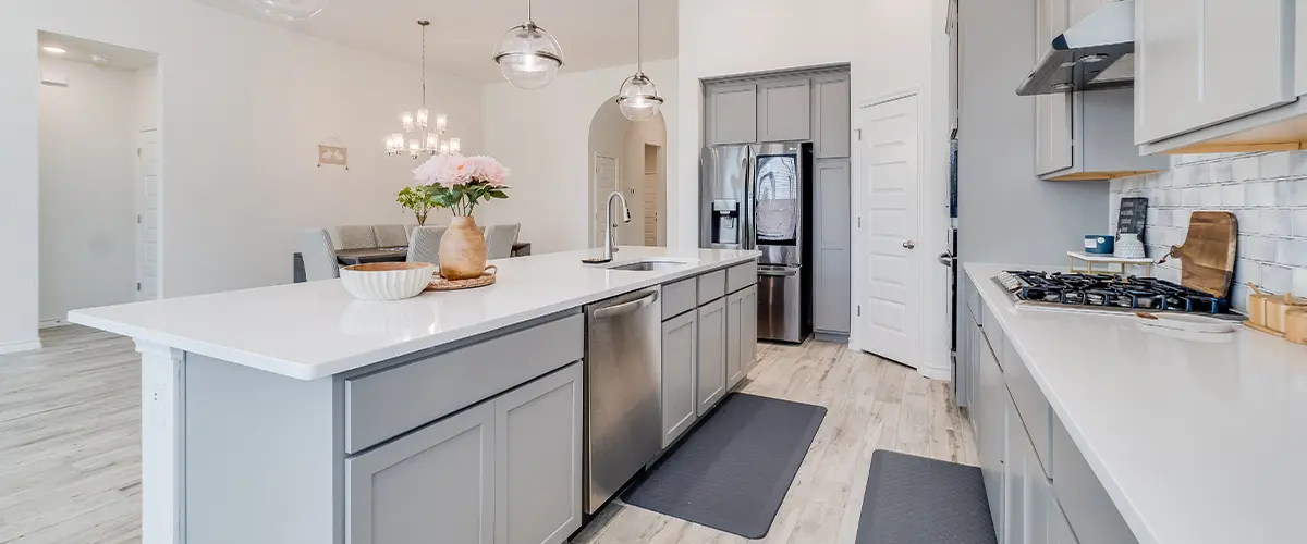 Spacious open-concept kitchen with gray cabinets, large island, and pendant lighting, perfect for hosting and cooking.