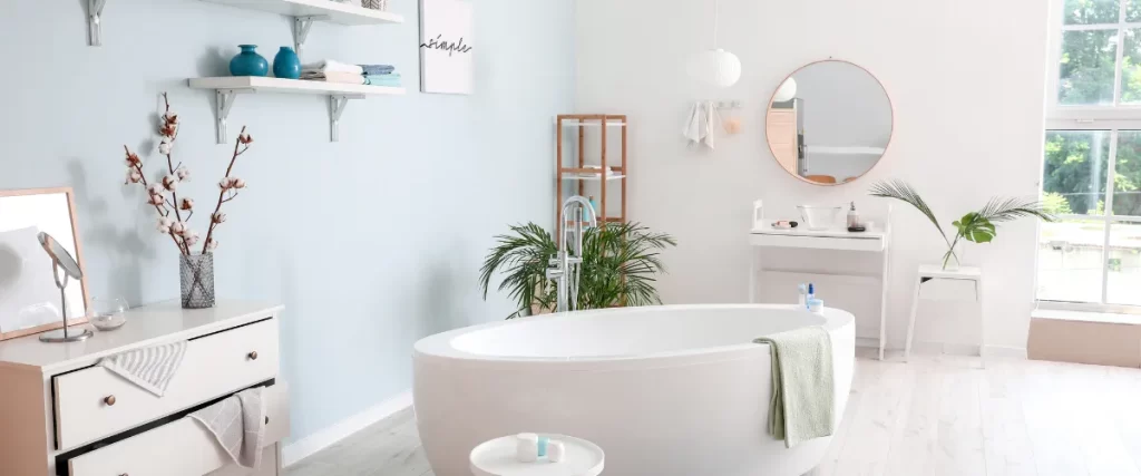 Bright and stylish bathroom featuring a freestanding bathtub and decorative plants.