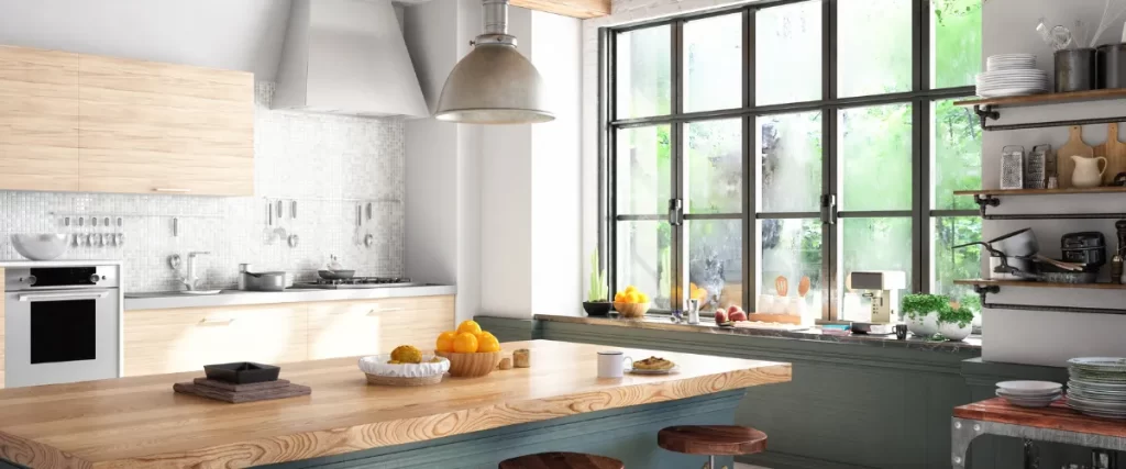 Bright kitchen with a wooden countertop, large windows, and hanging pendant lights.