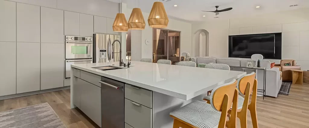 Contemporary open-concept kitchen with large island, wood pendant lights, and stainless steel appliances