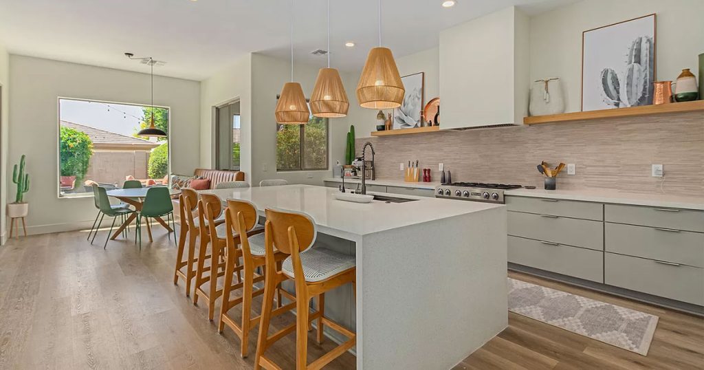 Contemporary-open-concept-kitchen-with-large-island,-wood-pendant-lights,-and-stainless-steel-appliances