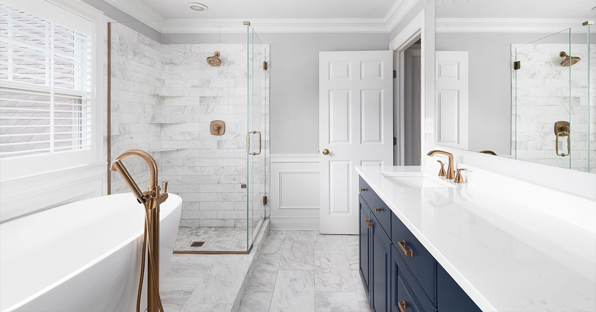Luxury bathroom with marble shower, freestanding tub, double vanity, and gold fixtures for modern home remodel