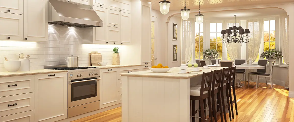 Spacious white kitchen with island seating, chandelier-lit dining nook, and hardwood floors - on page