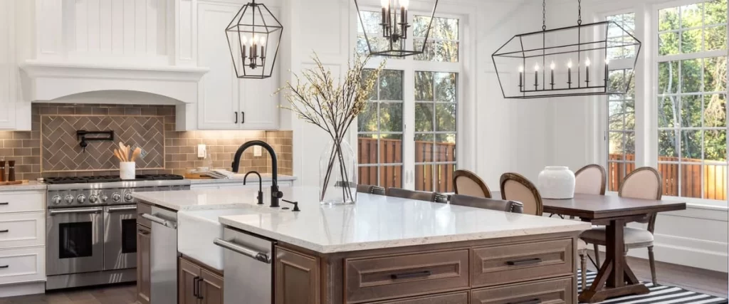 Spacious luxury kitchen featuring a white wood range hood, herringbone tile backsplash, and a dark wood island with a white quartz countertop.