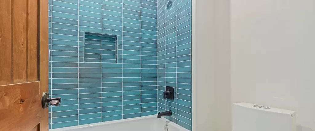 Modern bathroom with blue subway tile shower surround and matte black fixtures