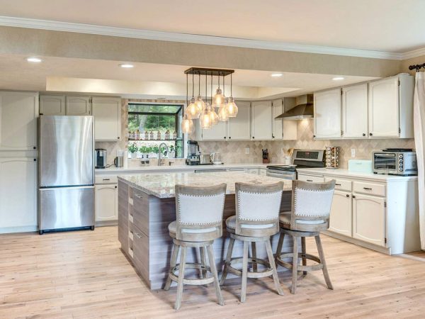 Large kitchen with very light wood floors and white cabinets
